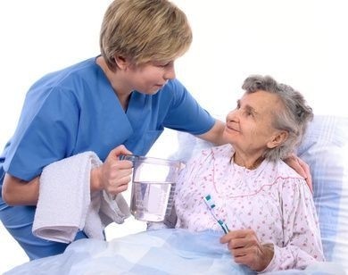 ležící pacientka vykonává hygienu s pomocí zdravotní sestry