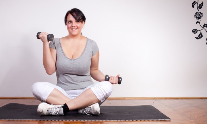 obézní žena hubne cvičením s činkami