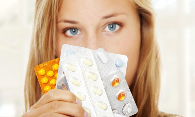 mladá žena drží platíčka antikoncepce