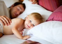 dítě v posteli s tatínkem