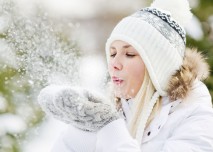 žena fouká do sněhových vloček