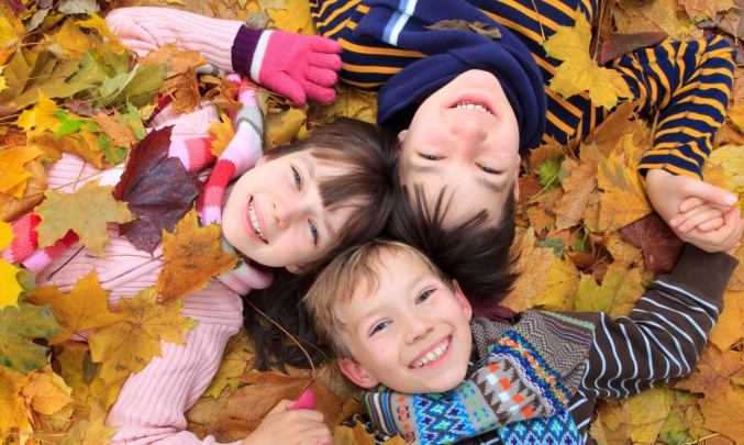 děti leží ve spadaném listí
